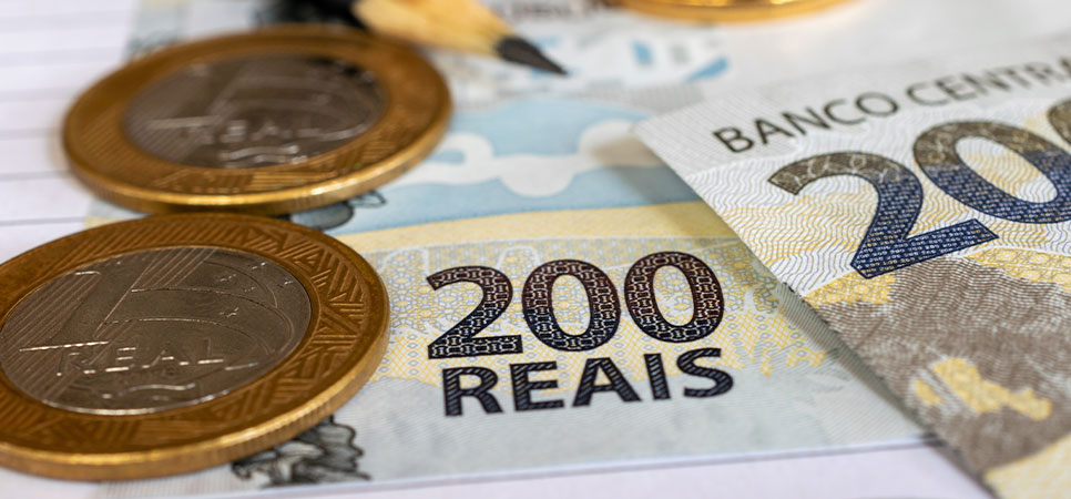 Notas e moedas de real simbolizando o custo de produção agrícola e o retorno financeiro por hectare no cultivo de milho